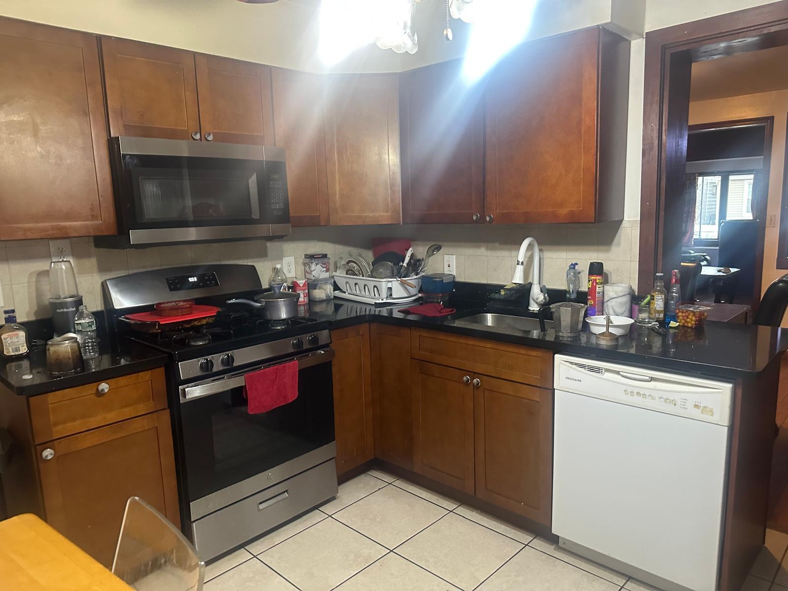 81-11 91st Avenue Queens, NY 11421 - Photo 6 of 15 a kitchen with stainless steel appliances a stove a microwave and sink