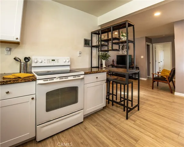 a kitchen with a stove oven and a table with wooden floor