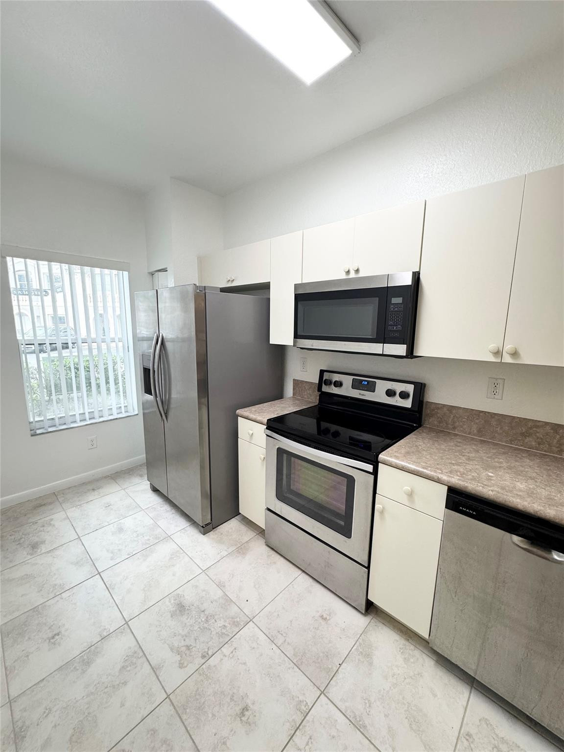 4903 Southwest 140th Terrace Miramar, FL 33027 - Photo 3 of 19 a kitchen with a stove a refrigerator and a fireplace