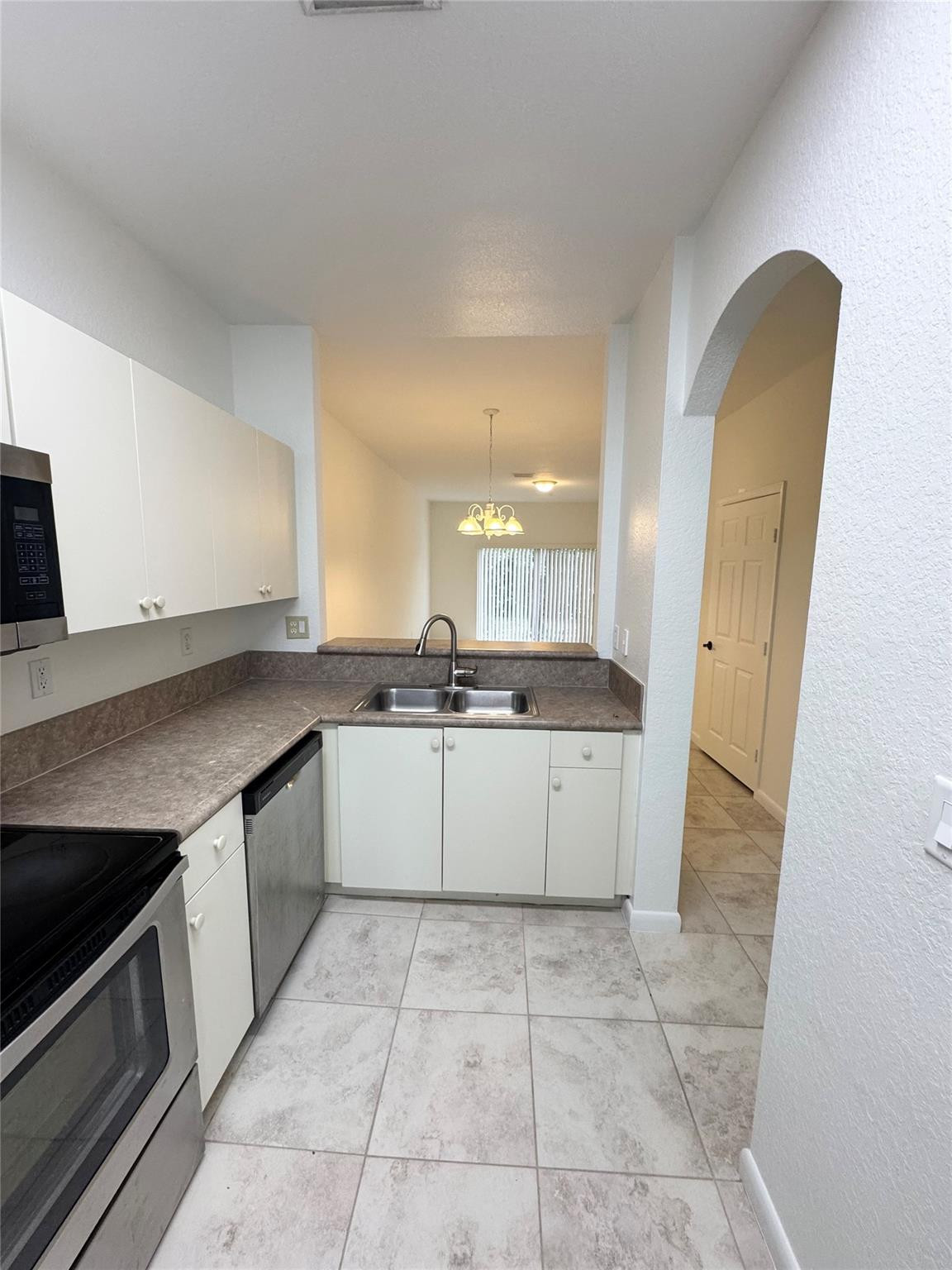 4903 Southwest 140th Terrace Miramar, FL 33027 - Photo 4 of 19 a kitchen with a sink a stove top oven and cabinets
