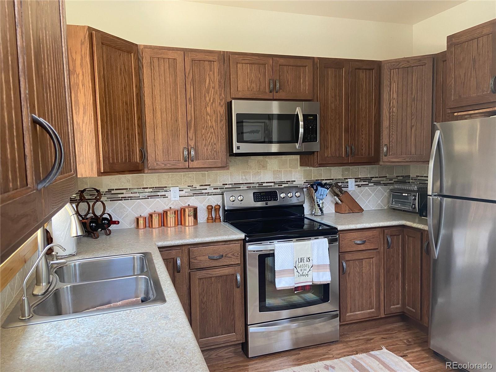 538 Campfire Road Hartsel, CO 80449 - Photo 5 of 40 a kitchen with stainless steel appliances granite countertop a refrigerator stove and sink