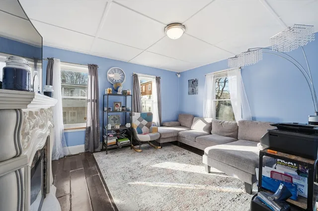 a living room with furniture a fireplace and a window