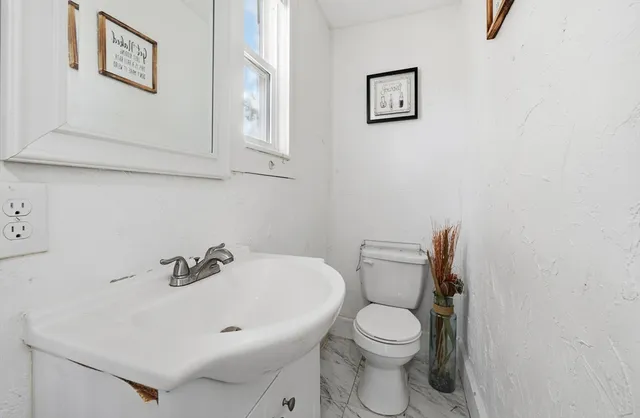 a white toilet sitting next to a white sink