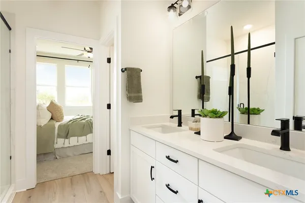 a bathroom with double vanity sink a mirror and shower