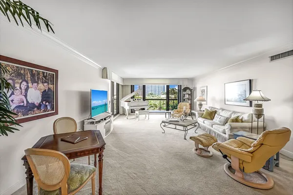 a living room with furniture a couch and paintings on the wall
