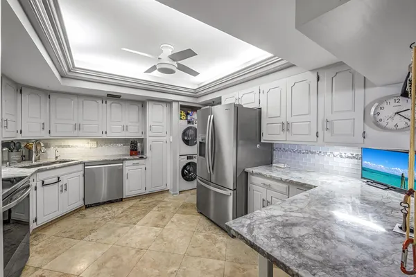 a kitchen with granite countertop a refrigerator oven a sink and cabinets