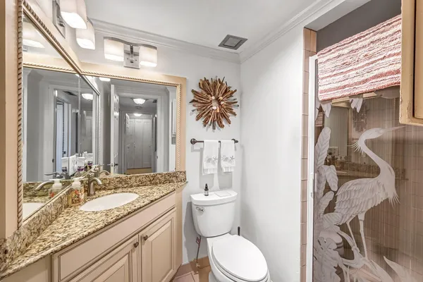 a bathroom with a granite countertop sink a toilet and a mirror