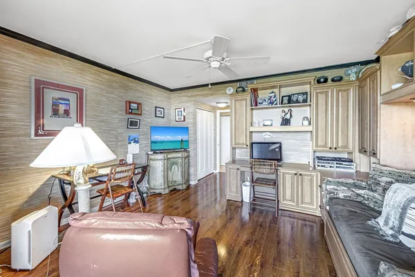 a living room with stainless steel appliances furniture and a kitchen view