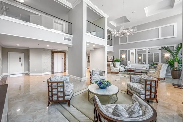 a dining room with furniture a kitchen and chandelier