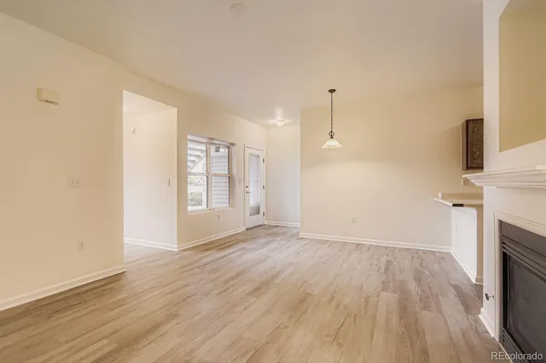 an empty room with wooden floor and a fireplace
