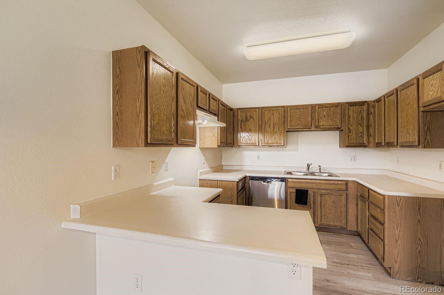 3261 South Waco Court, Unit B Aurora, CO 80013 - Photo 5 of 21 a kitchen with stainless steel appliances granite countertop a sink stove and refrigerator