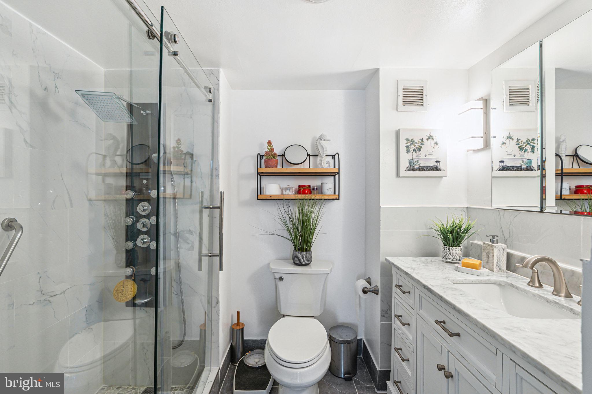 3600 Conshohocken Avenue, Unit 1712 Philadelphia, PA 19131 - Photo 14 of 27 a bathroom with a shower sink vanity mirror and toilet