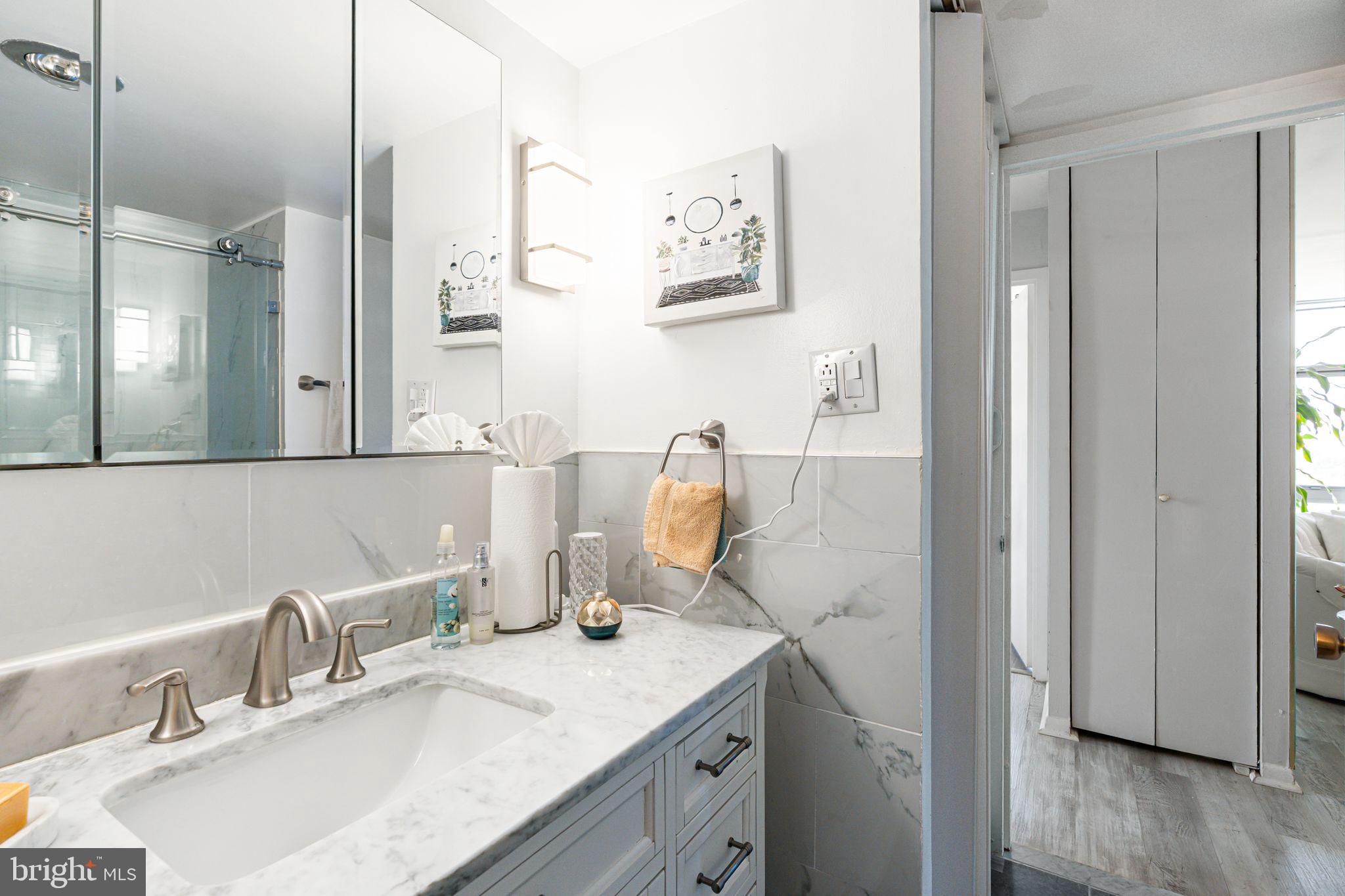 3600 Conshohocken Avenue, Unit 1712 Philadelphia, PA 19131 - Photo 17 of 27 a bathroom with a granite countertop sink and a mirror
