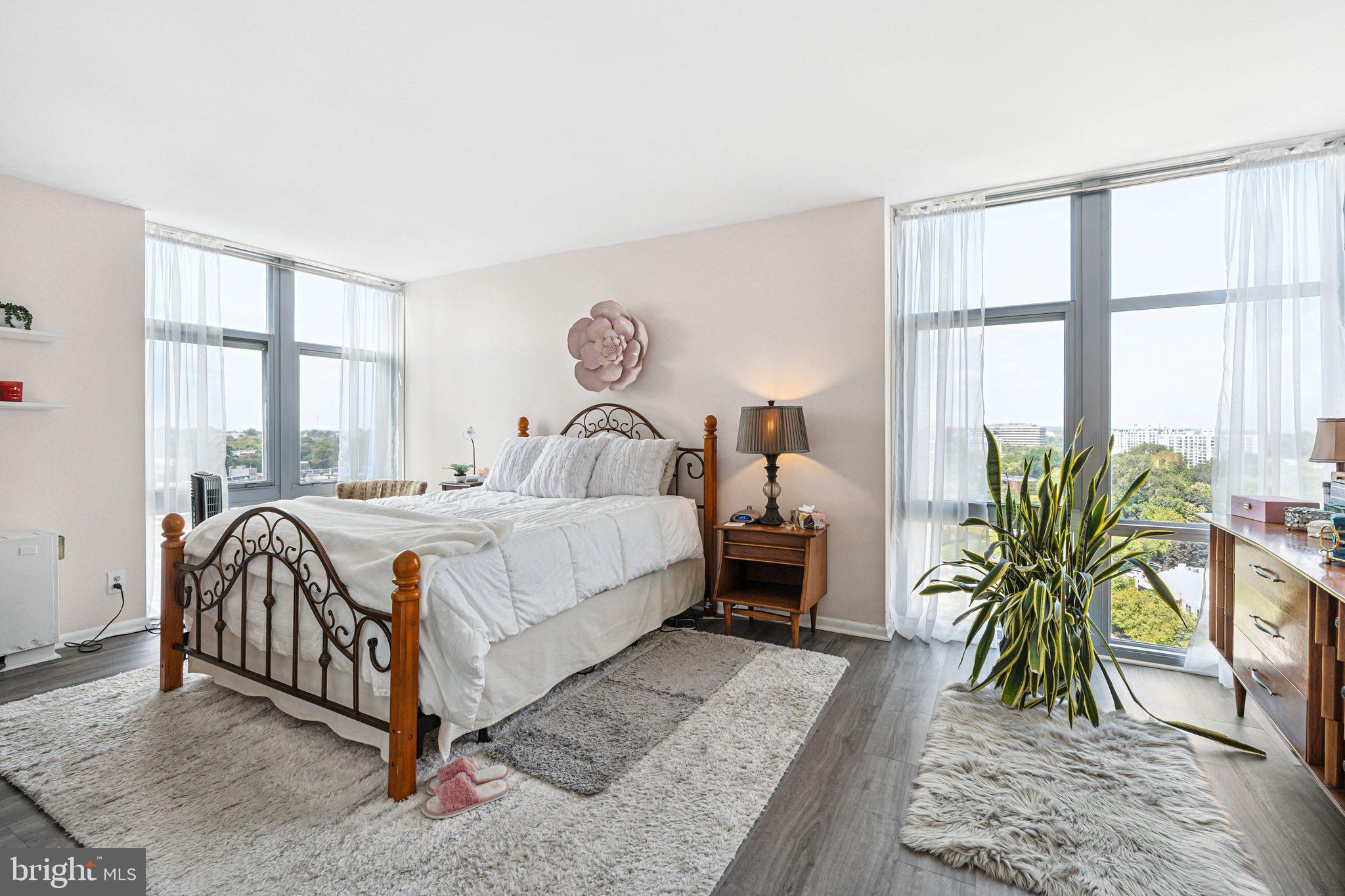 3600 Conshohocken Avenue, Unit 1712 Philadelphia, PA 19131 - Photo 18 of 27 a bedroom with a bed table flowerpot and a window