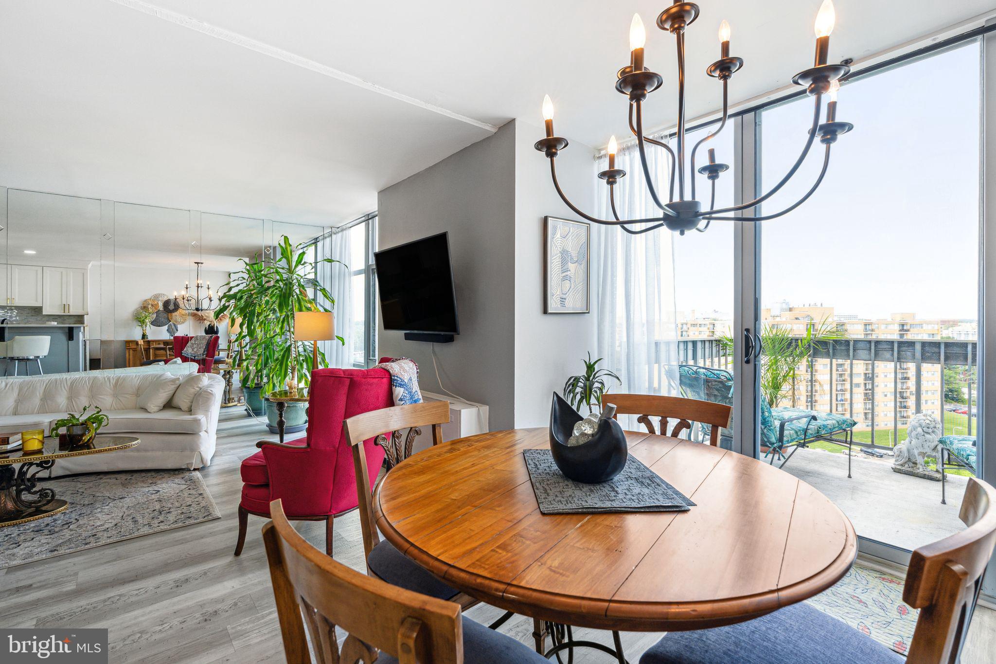 3600 Conshohocken Avenue, Unit 1712 Philadelphia, PA 19131 - Photo 5 of 27 a living room with furniture a flat screen tv and a floor to ceiling window