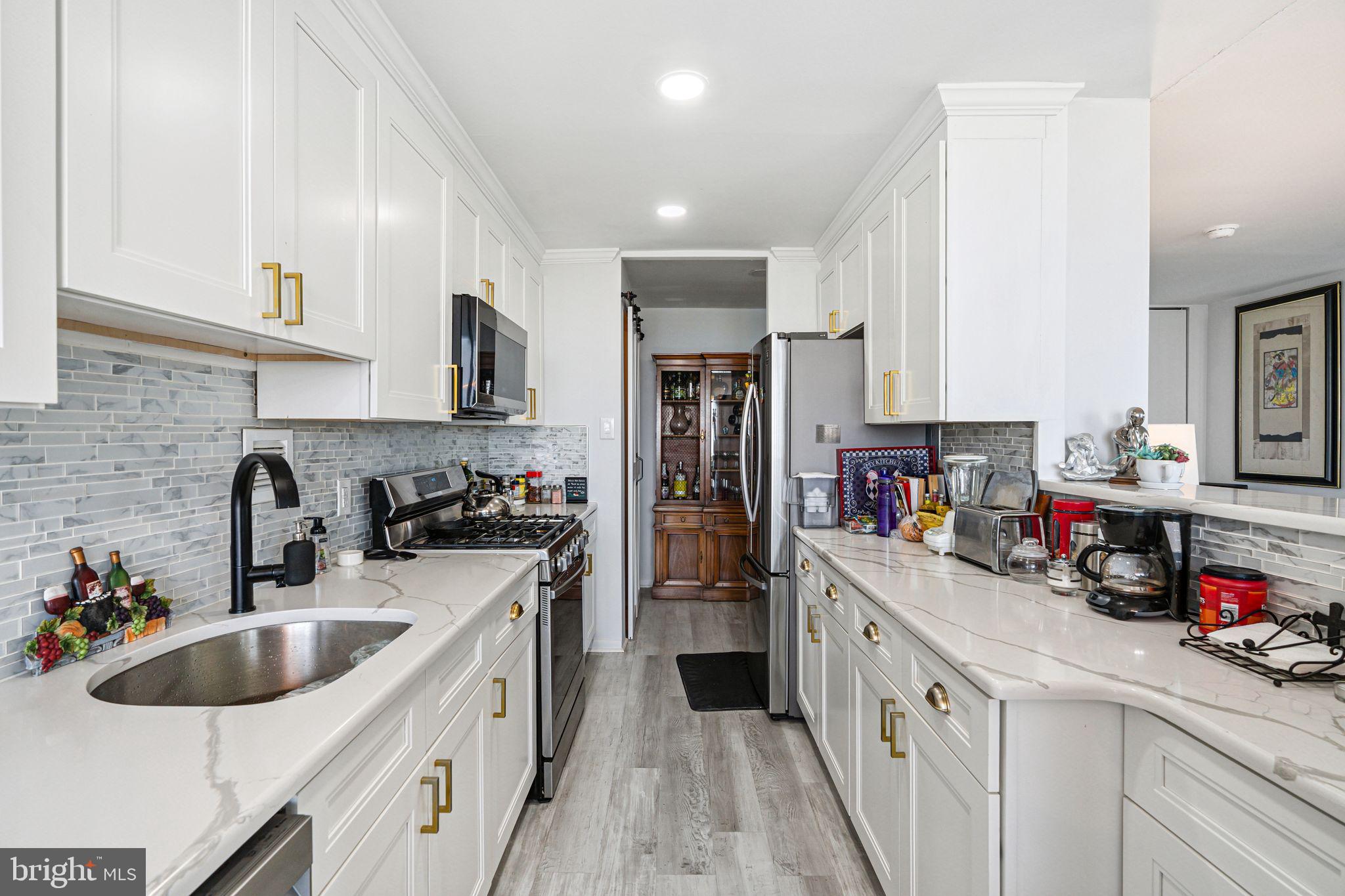 3600 Conshohocken Avenue, Unit 1712 Philadelphia, PA 19131 - Photo 9 of 27 a kitchen with refrigerator a sink and cabinets