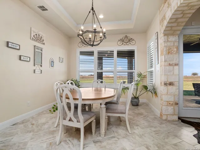 a view of a dining room with furniture and chandelier