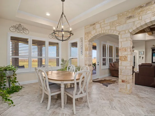 a dining room with wooden floor a chandelier a wooden table and chairs