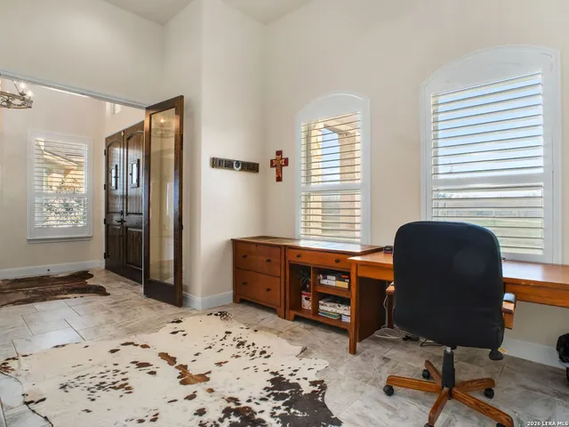 a view of a workspace with furniture and a window