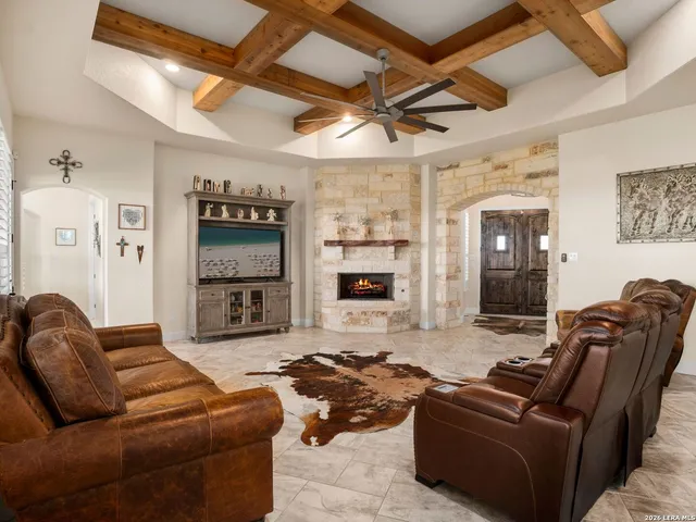 a living room with furniture a flat screen tv and a fireplace