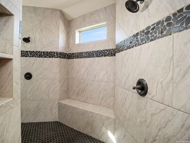 a bathroom with a tub a sink and mirror