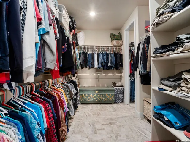 a view of walk in closet with clothes and shoes