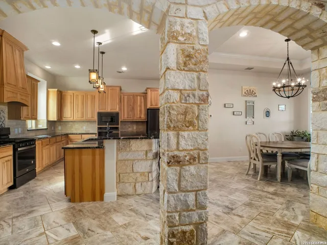 a kitchen with stainless steel appliances granite countertop a sink a stove a refrigerator and cabinets