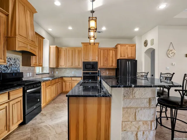 a kitchen with granite countertop a sink stainless steel appliances and cabinets