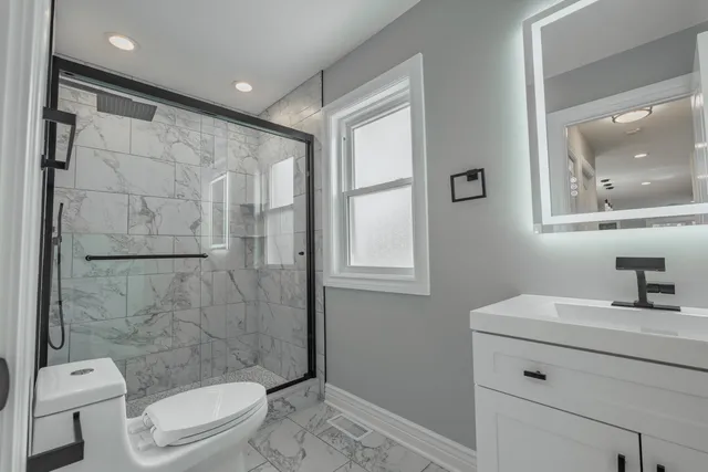 a bathroom with a sink a toilet and shower