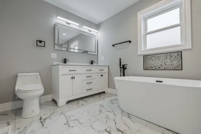 a spacious bathroom with a toilet sink and mirror