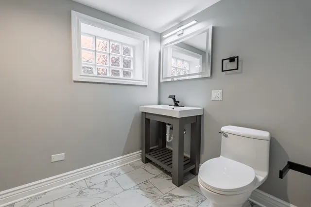 a bathroom with a toilet a sink and mirror
