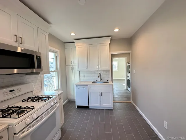 a kitchen with granite countertop a sink stove and cabinets