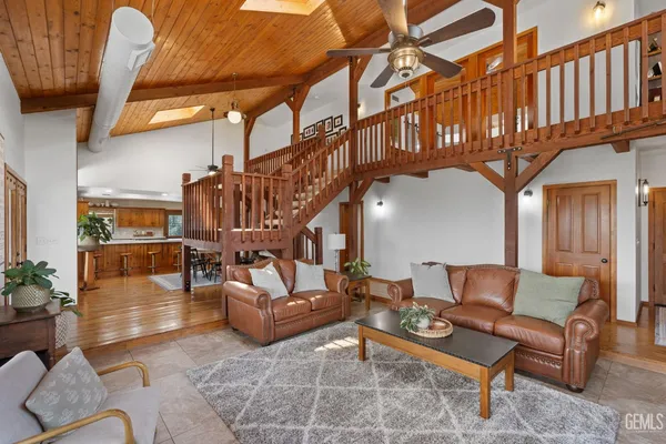 a living room with furniture a ceiling fan and a rug