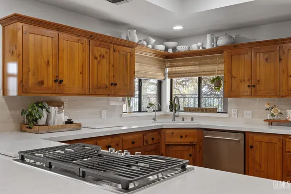 a kitchen with stainless steel appliances granite countertop a stove a sink dishwasher and cabinets with wooden floor