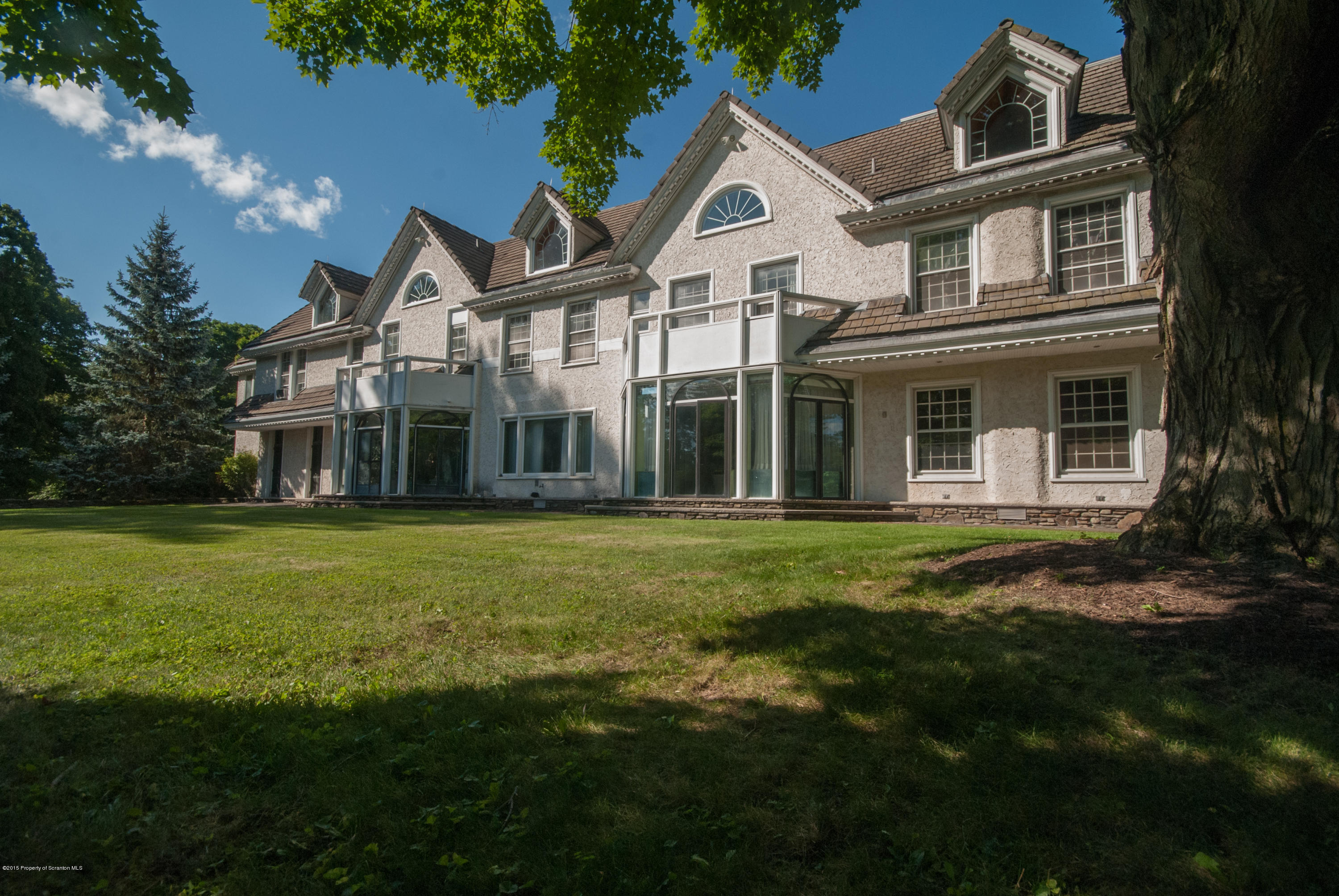 145 Carbondale Road Waverly, PA 18471 - Photo 1 of 98 a view of a white house with a big yard and potted plants and large trees