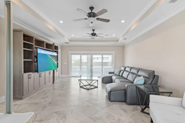 a living room with furniture floor to ceiling window and a ceiling fan