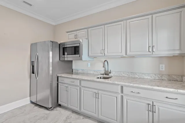 a bedroom with a large bed chandelier and a window
