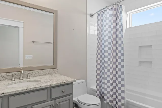 a bedroom with a bed tv and a window