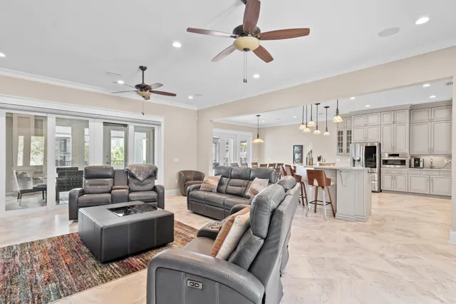 a living room with furniture kitchen view and a chandelier