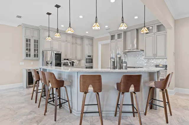 a kitchen with kitchen island granite countertop a table chairs sink and cabinets