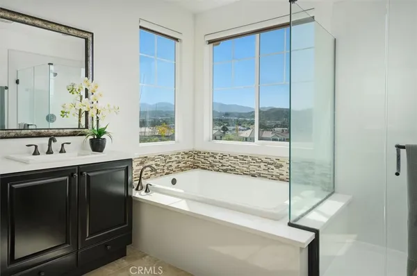 a bathroom with a sink a toilet a mirror and shower