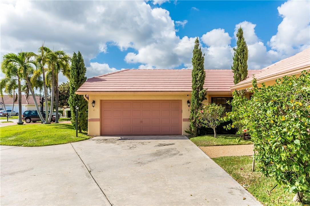 22870 Greenview Terrace Boca Raton, FL 33433 - Photo 48 of 57 a front view of a house with a yard and a garage