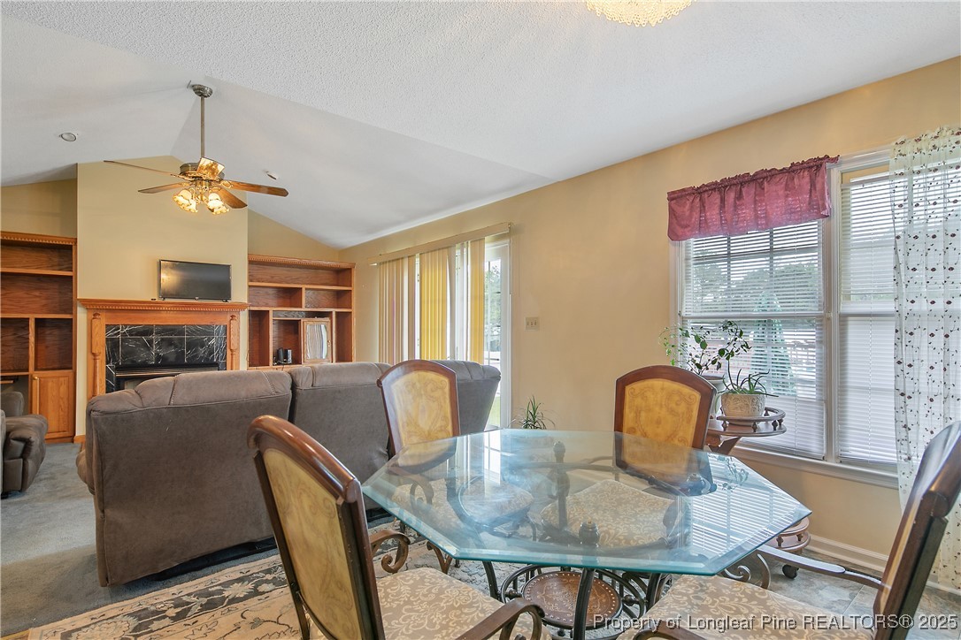 6042 Elliott Bridge Road Linden, NC 28356 - Photo 12 of 47 a living room with furniture a dining table and a chandelier