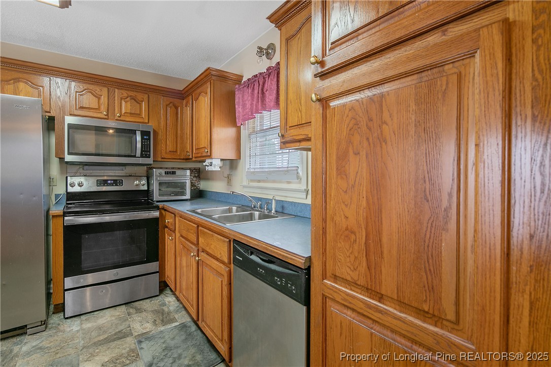 6042 Elliott Bridge Road Linden, NC 28356 - Photo 16 of 47 a kitchen with stainless steel appliances granite countertop a stove microwave and refrigerator