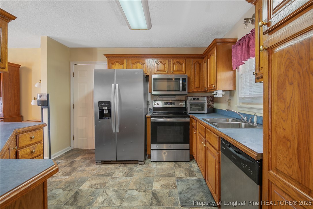 6042 Elliott Bridge Road Linden, NC 28356 - Photo 17 of 47 a kitchen with stainless steel appliances granite countertop a stove a refrigerator and a stove