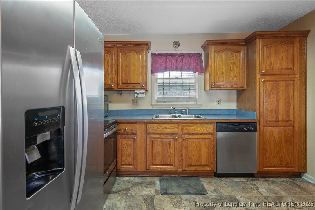 6042 Elliott Bridge Road Linden, NC 28356 - Photo 19 of 47 a kitchen with stainless steel appliances granite countertop a refrigerator and a sink