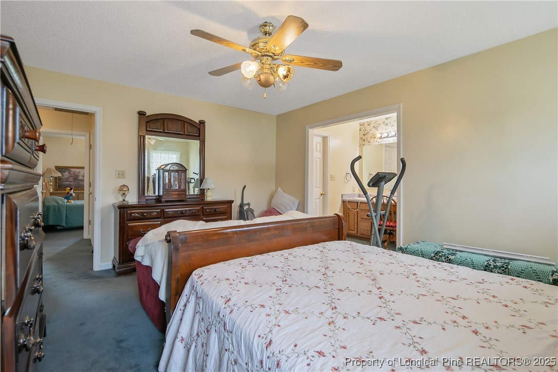 6042 Elliott Bridge Road Linden, NC 28356 - Photo 24 of 47 a bedroom with bed and a chandelier