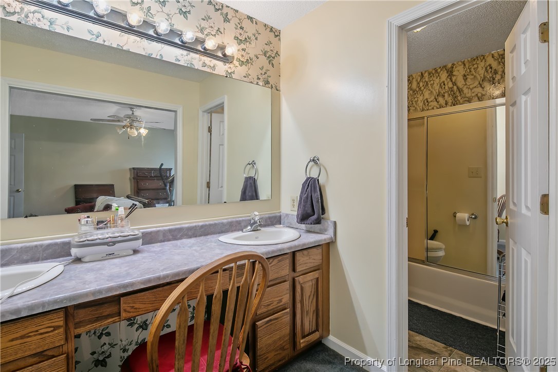 6042 Elliott Bridge Road Linden, NC 28356 - Photo 26 of 47 a bathroom with a granite countertop sink a mirror and a shower