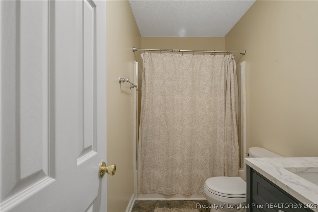 6042 Elliott Bridge Road Linden, NC 28356 - Photo 30 of 47 a bathroom with a granite countertop toilet and a shower
