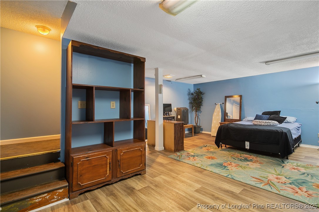 6042 Elliott Bridge Road Linden, NC 28356 - Photo 36 of 47 a bedroom with a bed and wooden floor